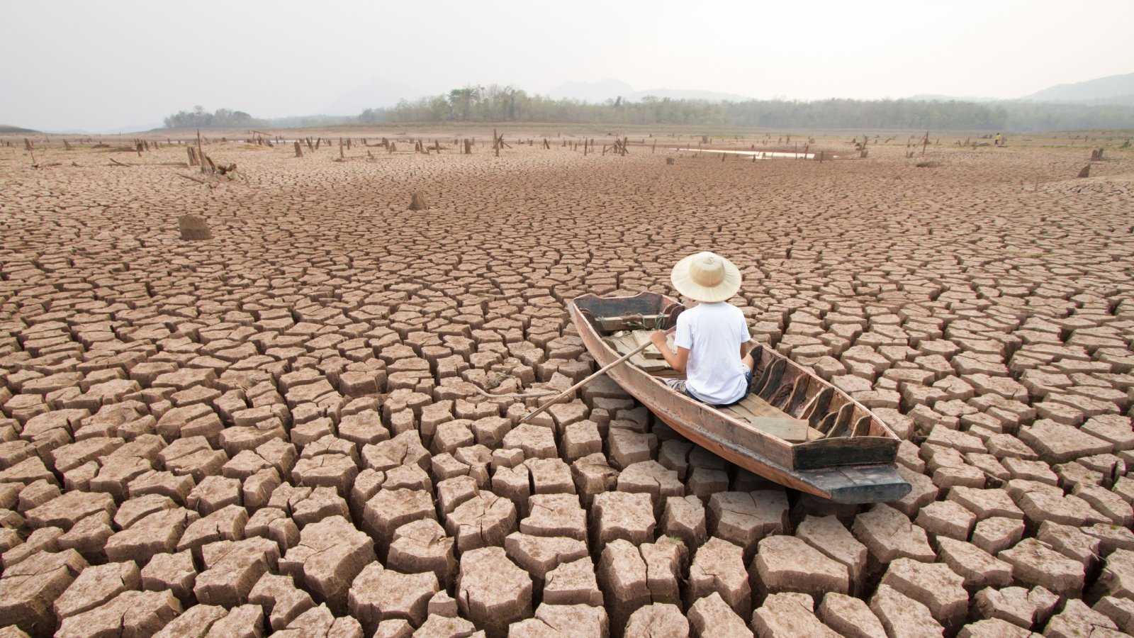 male in boat dry lake climate change