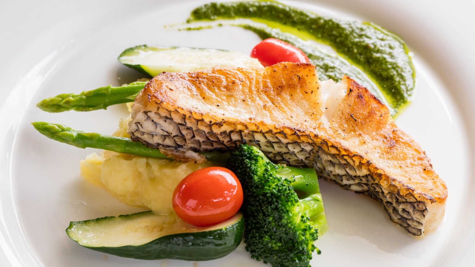 Black cod fish fillet with cucumber spinach sauce asparagus tomato carrot basil mashed potato 7th Son Studio Shutterstock