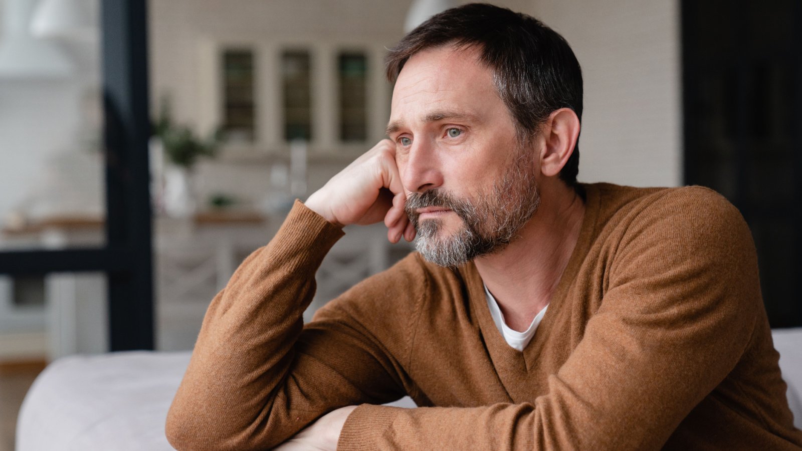 Bored tired sad mature middle aged male senior father depressed lonely sad grief inside creative house shutterstock