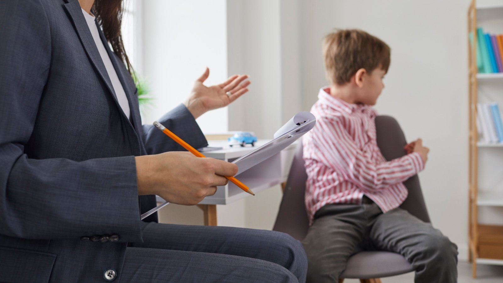 Boy with psychologist avoiding eye contact Studio Romantic Shutterstock