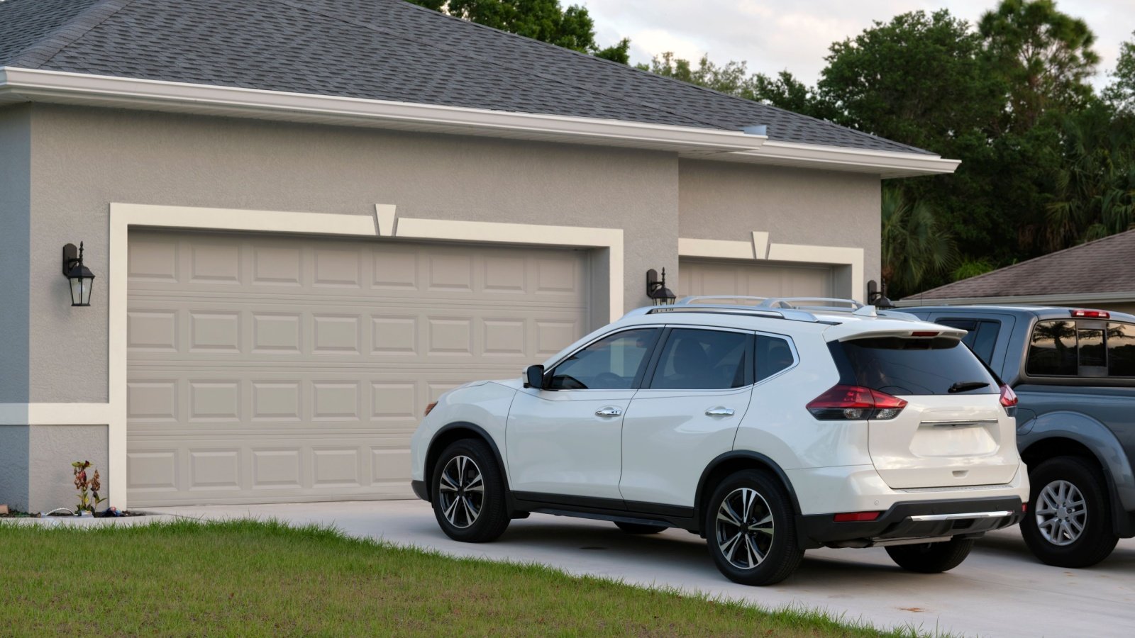 Car parked in front of garage on concrete driveway of new house home Bilanol Shutterstock