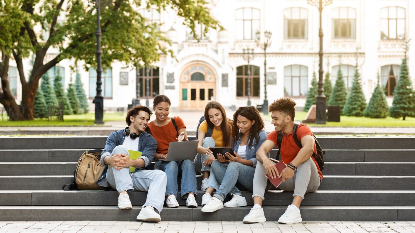 College University Students with Laptop Tablet and Backpacks Prostock studio Shutterstock