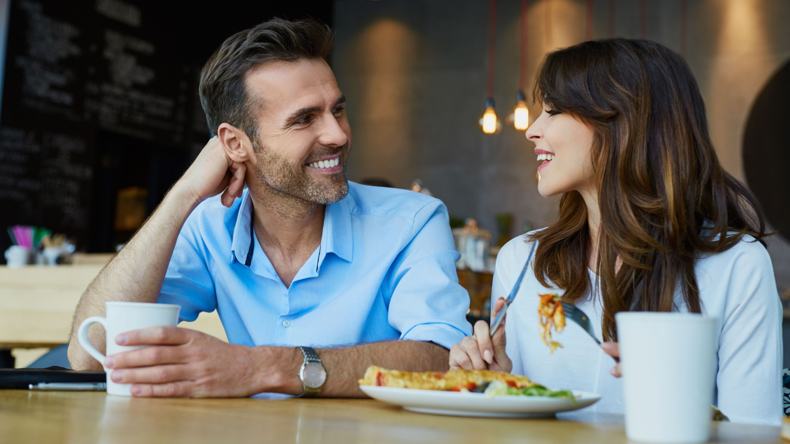 Couple at cafe talking during lunch dining eating restaurant baranq shutterstock