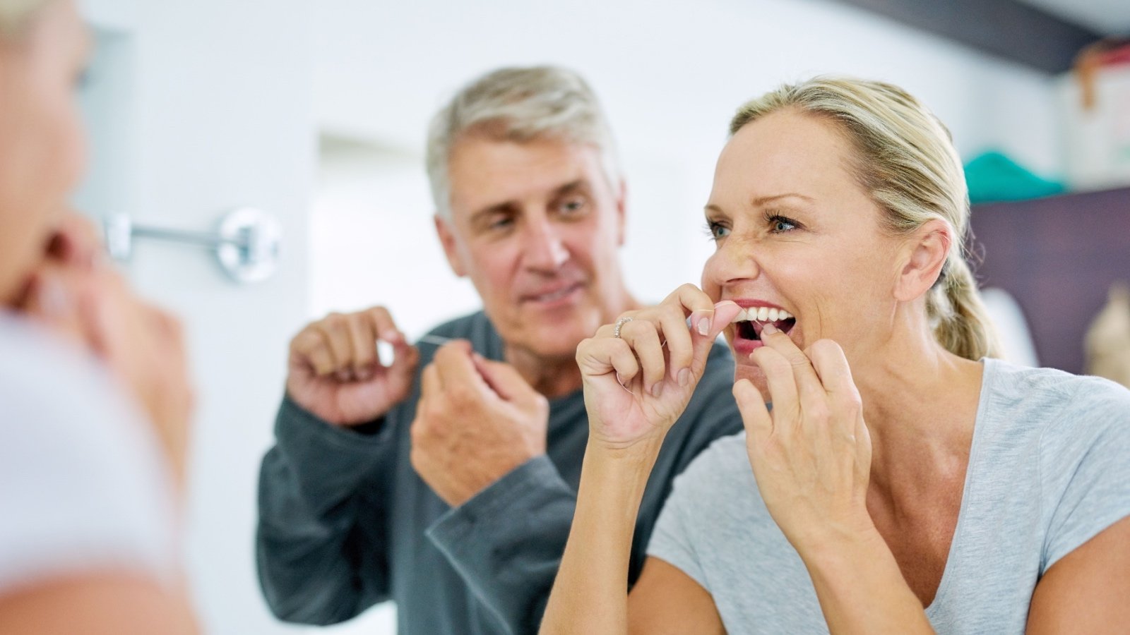 Couple flossing teeth in bathroom PeopleImages.com Yuri A Shutterstock