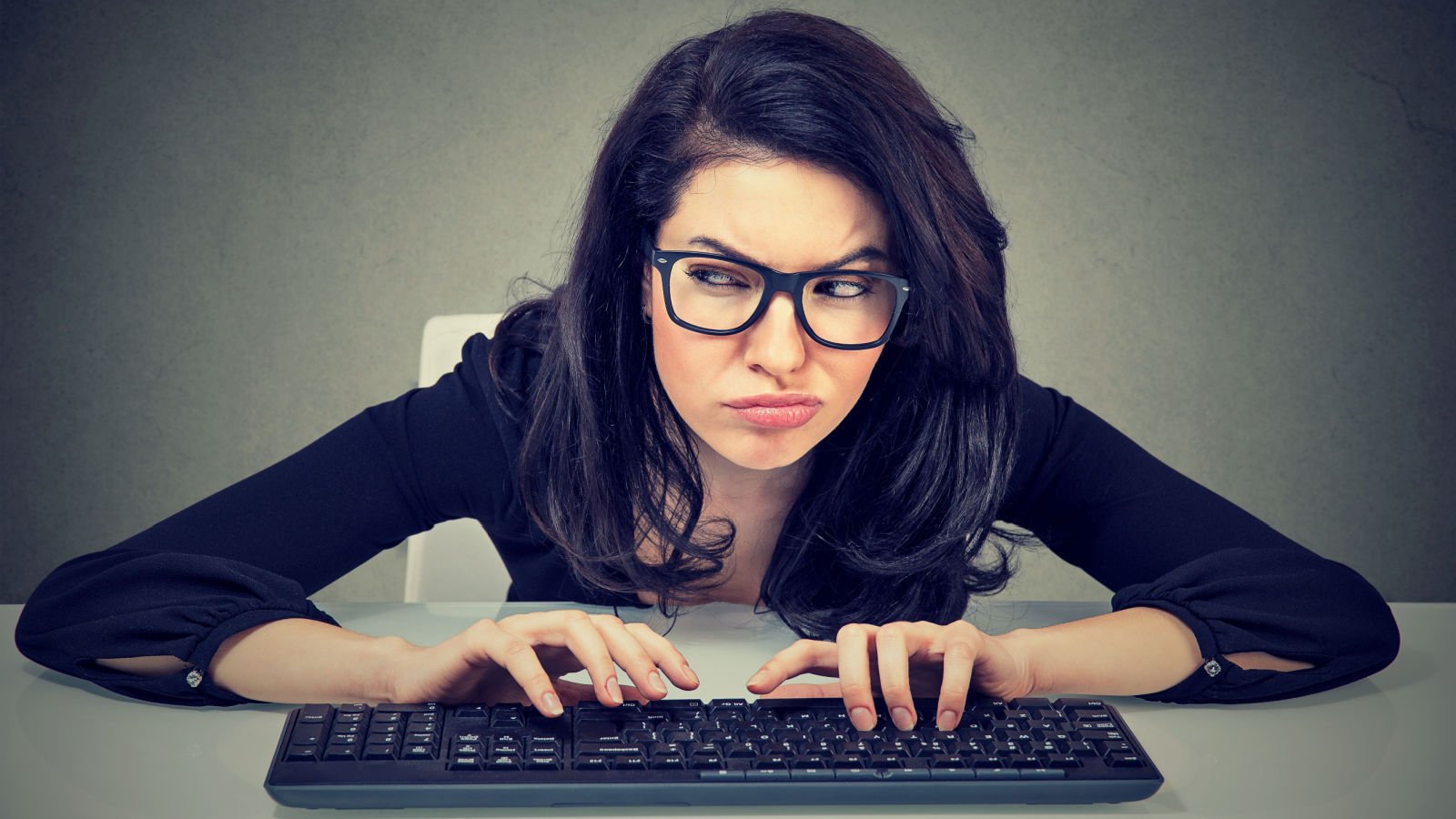 Crazy looking nerdy woman typing keyboard plotting revenge jobs work boss pathdoc shutterstock