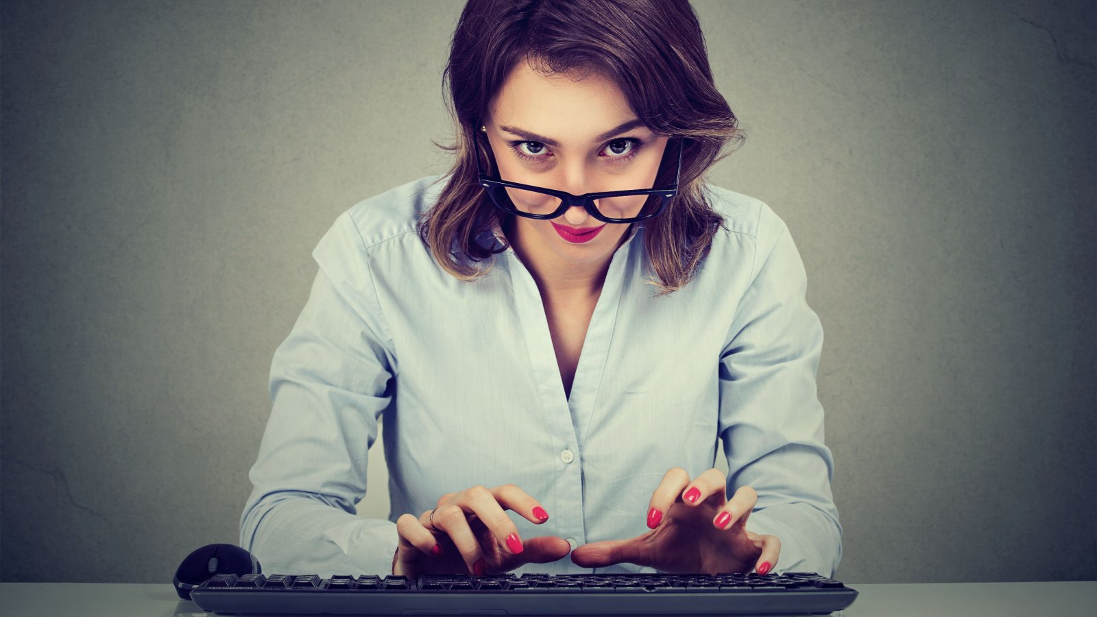 Crazy looking nerdy woman typing on the keyboard work pathdoc shutterstock