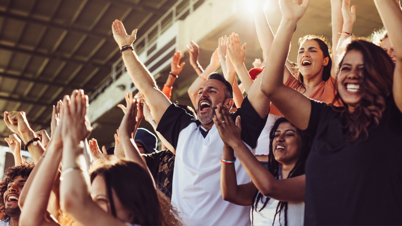 Crowd of sports fans cheering during a match in stadium clap yell win victory champion Jacob Lund Shutterstock