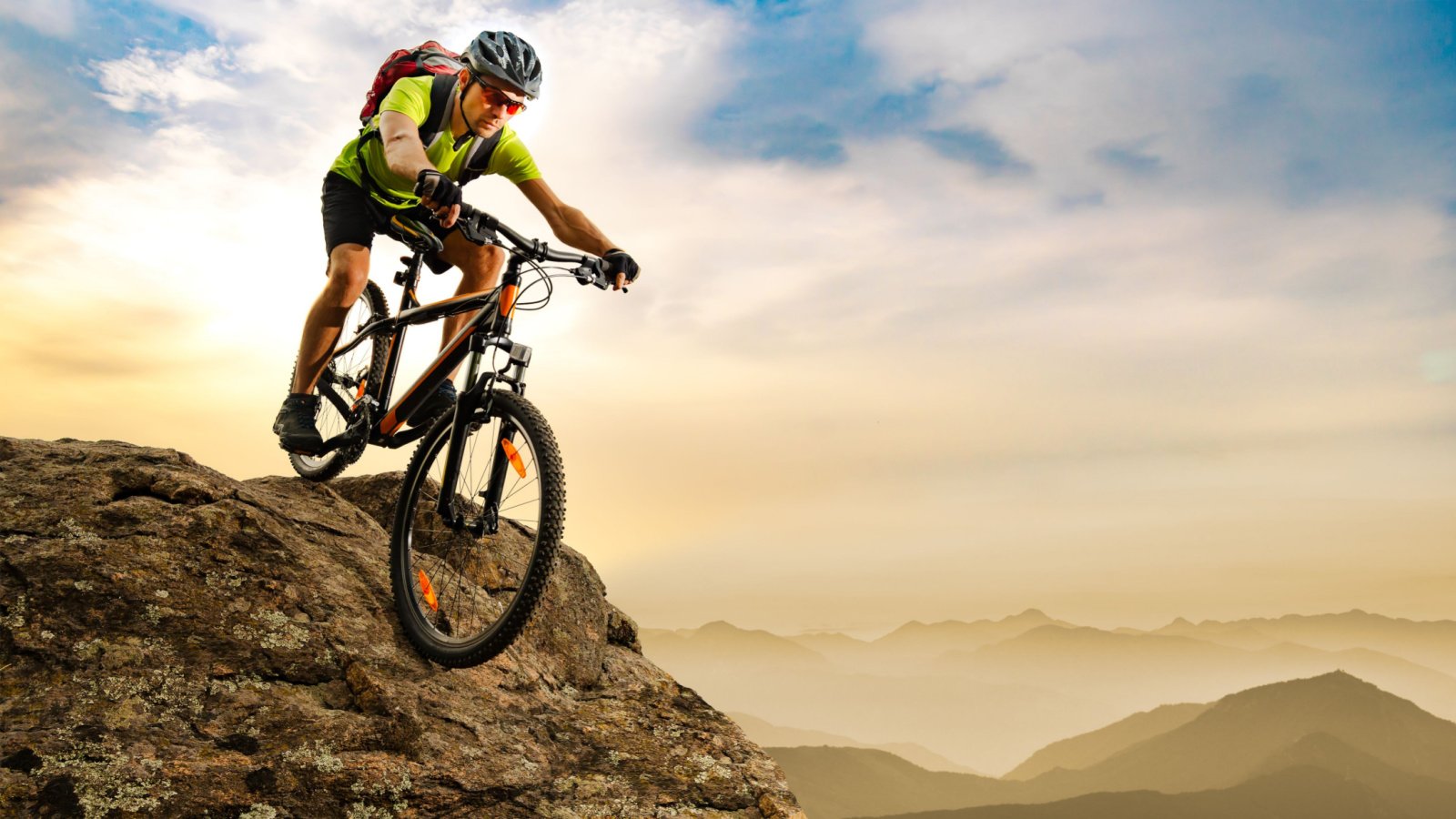 Cyclist Riding the Bike Down the Rock at Sunrise in the Beautiful Mountains Extreme sport maxpro shutterstock