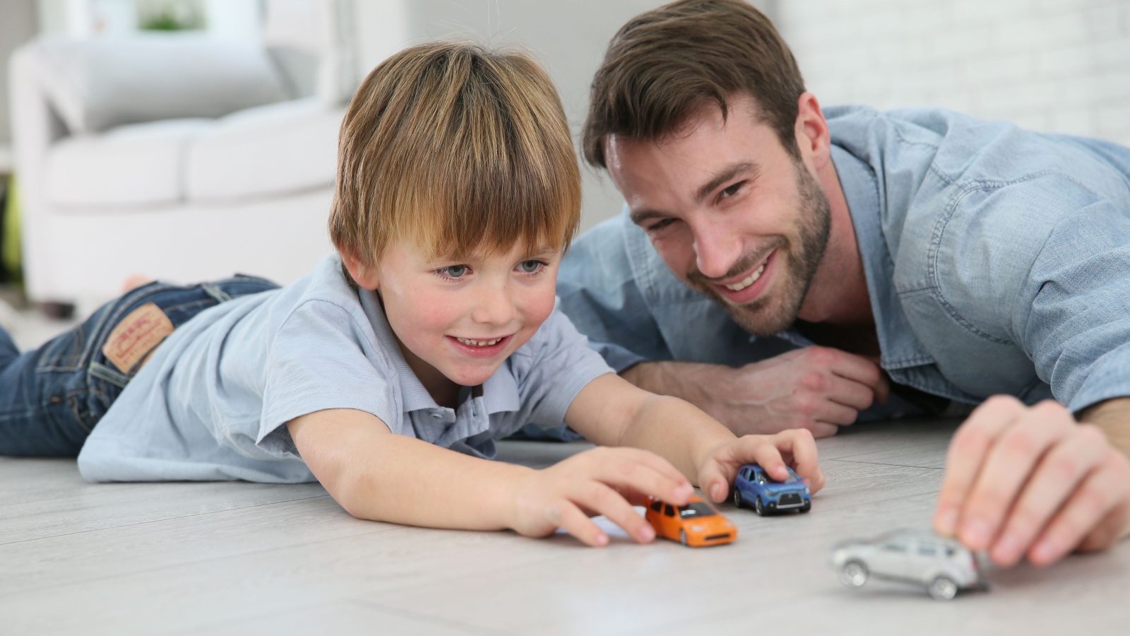 Dad and kid playing with toy cars goodluz Shutterstock