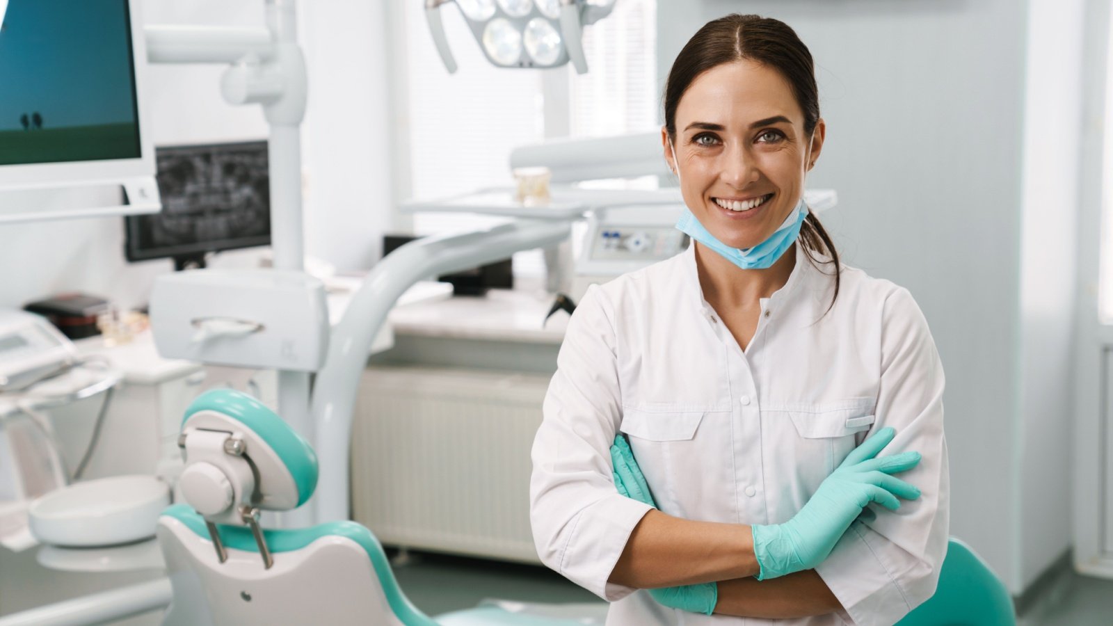 Dentist woman smiling while standing in dental clinic Dean Drobot Shutterstock Dentist woman smiling while standing in dental clinic Dean Drobot Shutterstock