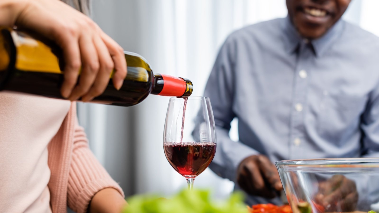 Dinner party with friends pouring wine into glass drink alcohol beverage bottle LightField Studios Shutterstock