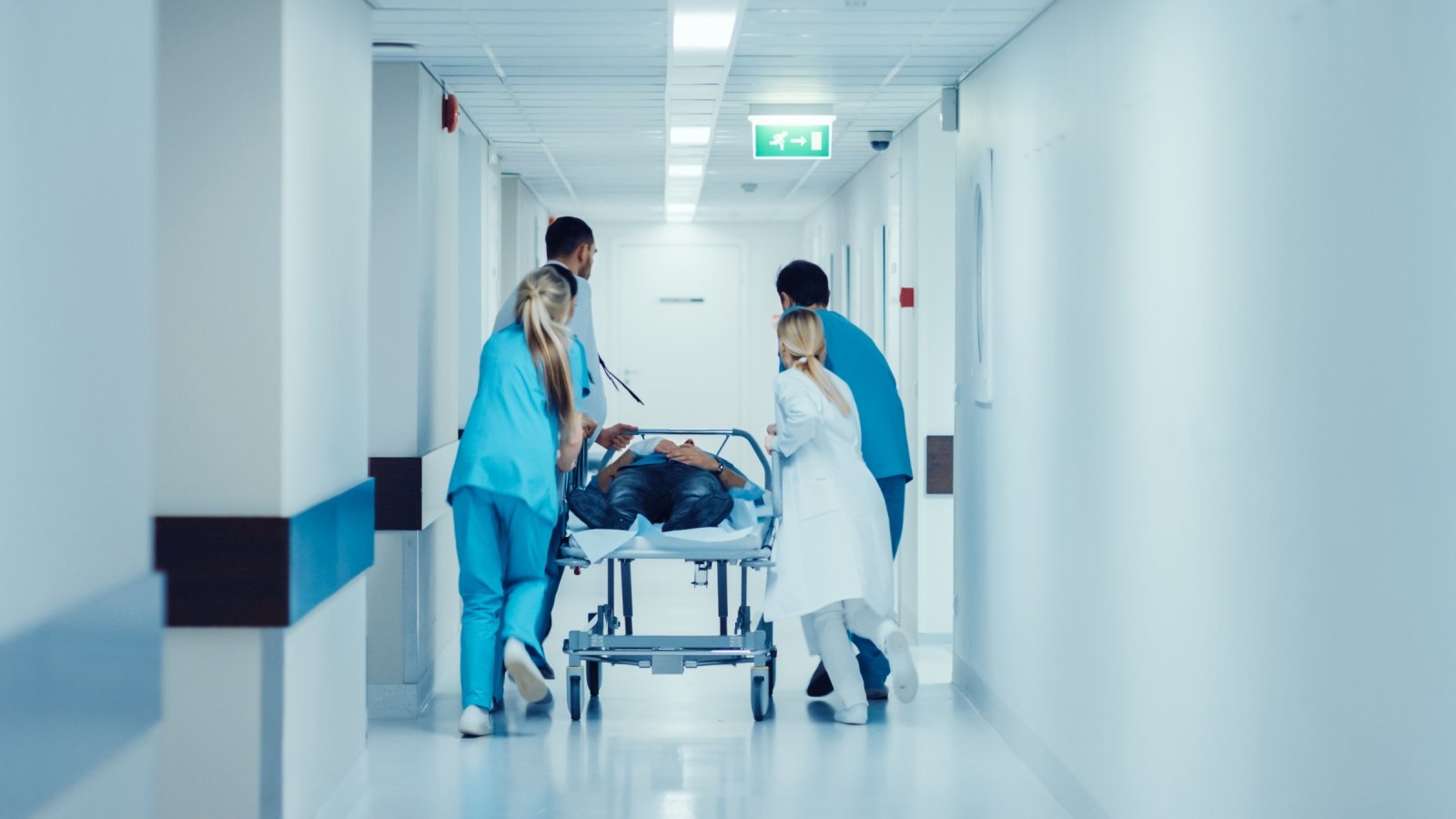 Doctors Nurses and Paramedics Push Gurney Stretcher Injury Patient Operation Hospital Emergency Room Medical Gorodenkoff Shutterstock