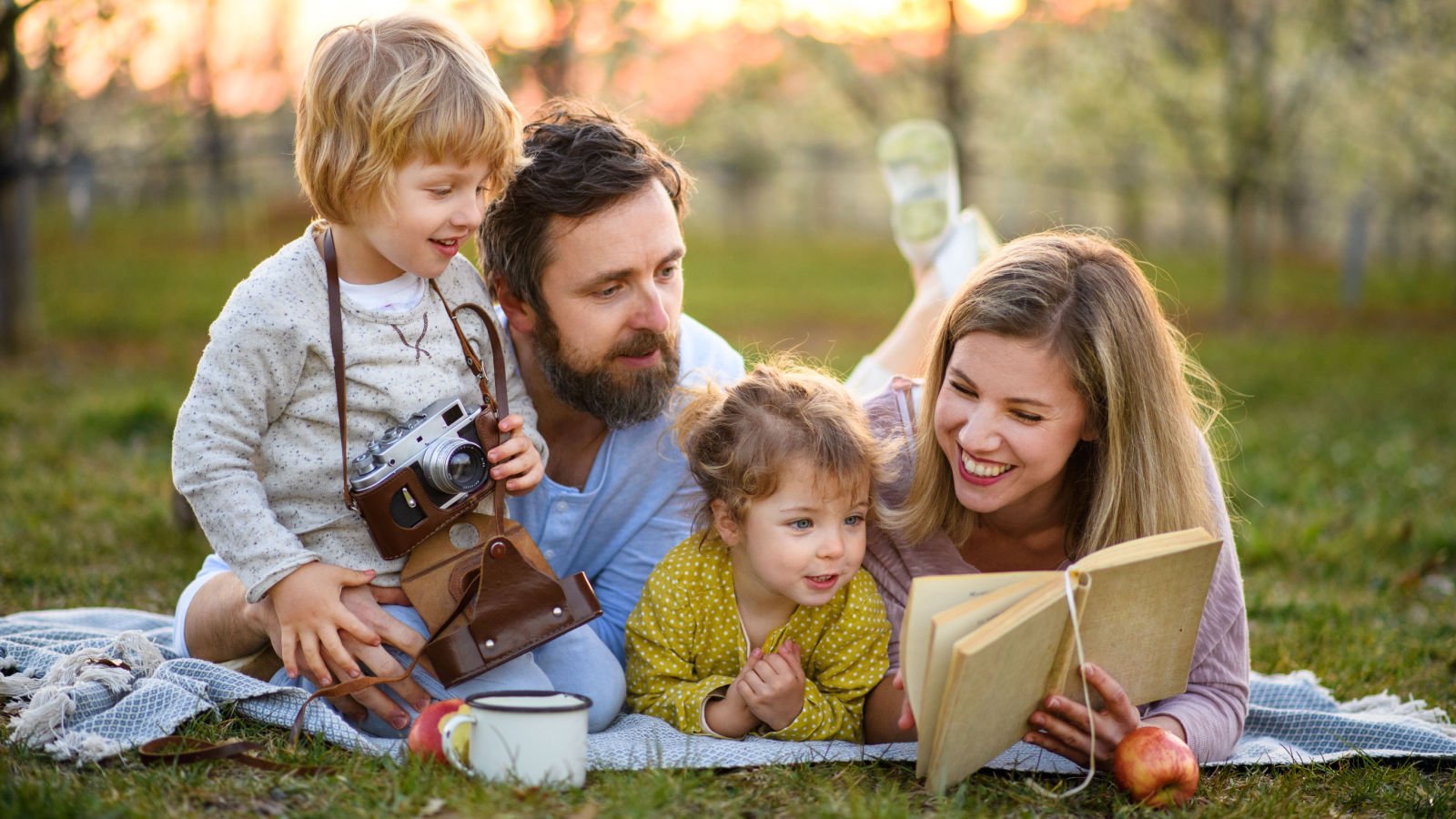 Family and small children with camera and book outdoors nature picnic ground picture shutterstock