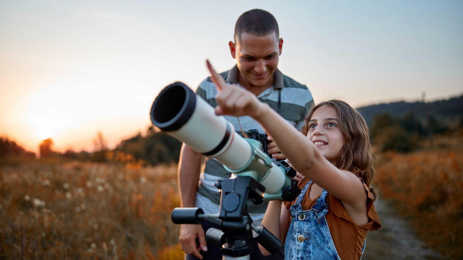 Father and daughter girl child kid observing the sky with a telescope True Touch Lifestyle Shutterstock