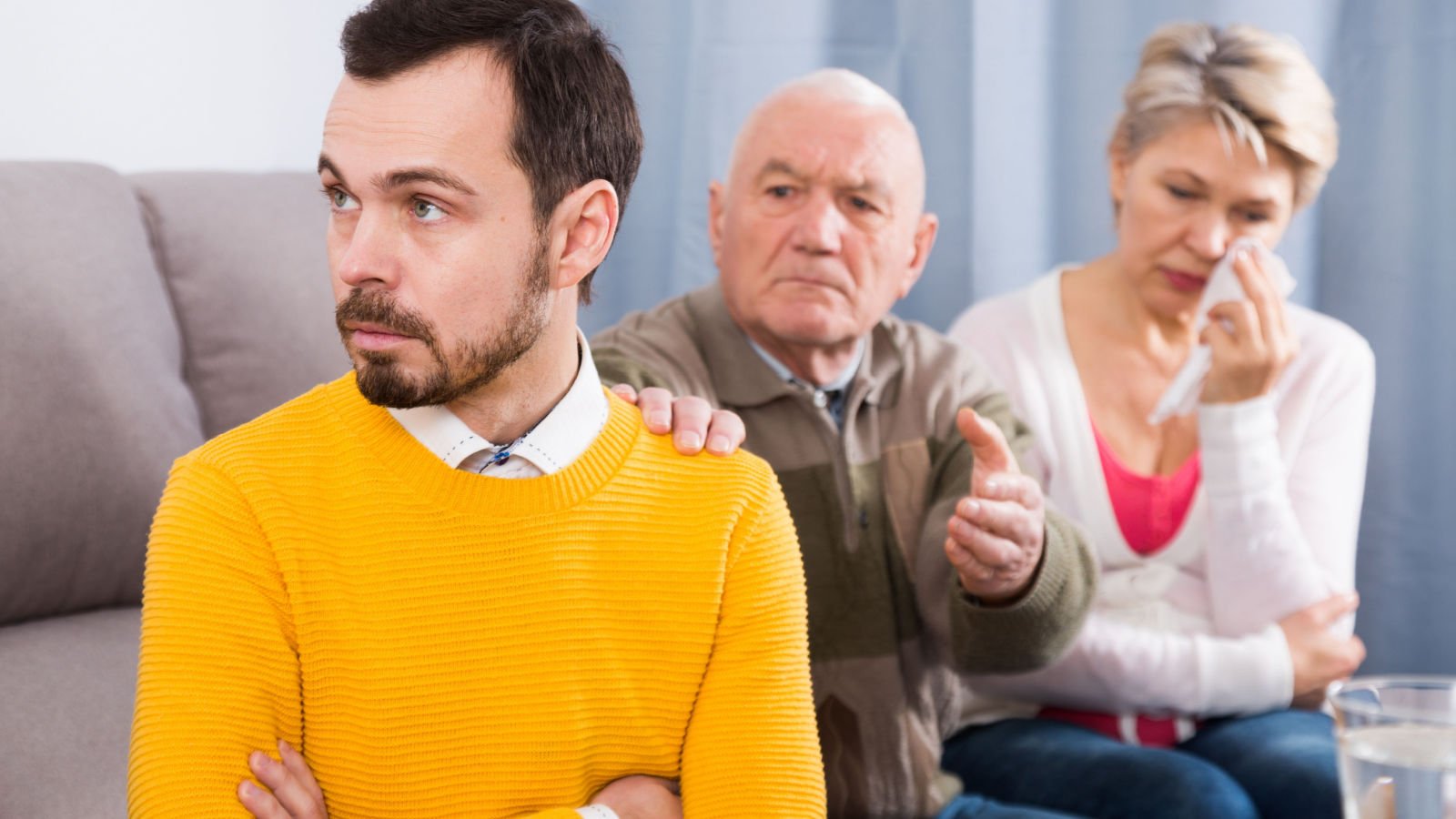 Father and mother having discussion on couch with adult son at home bear fotos shutterstock Father and mother having discussion on couch with adult son at home bear fotos shutterstock