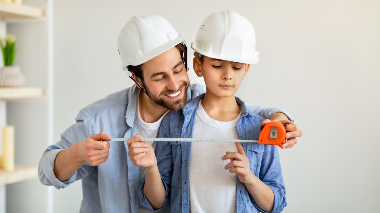 Father son tape measure construction repair Prostock studio Shutterstock