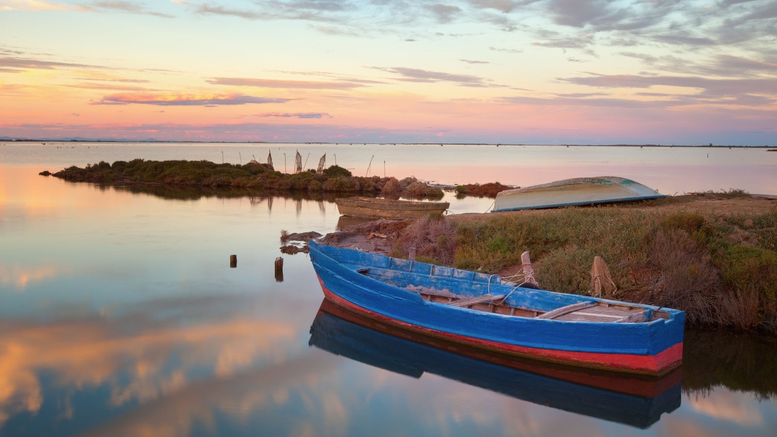 Fishing boats in a natural harbor in Fangar bay Ebro Delta Tarragona Spain Jose Arcos Aguilar Shutterstock