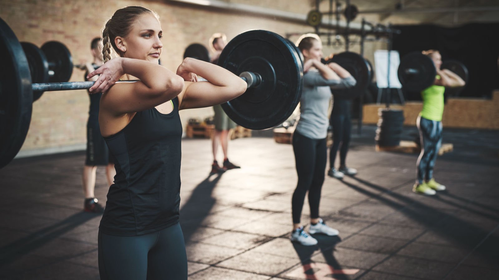 Fit young woman lifting barbells weights looking focused workout gym ground picture shutterstock