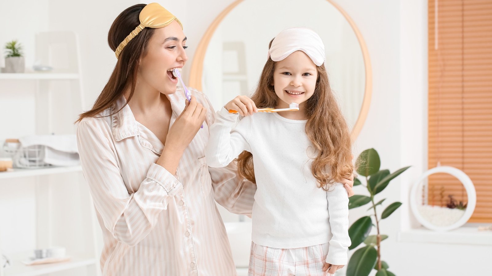 Girl and mother with sleeping masks brushing teeth in bathroom Pixel Shot Shutterstock