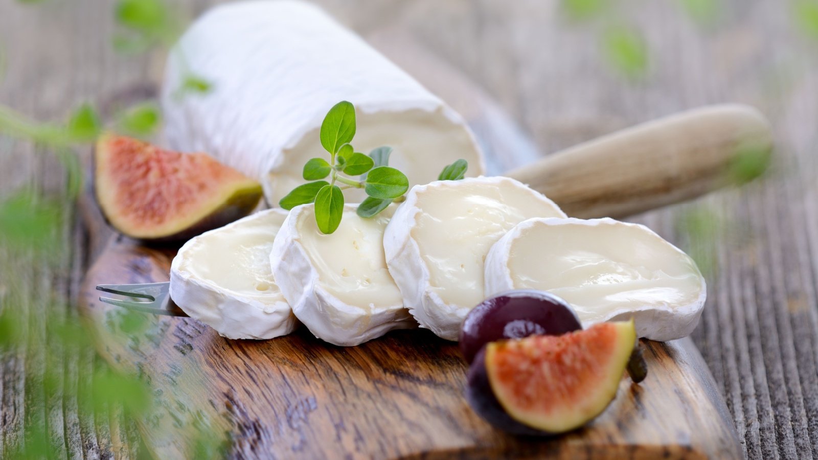 Goat cheese with figs and black olives on a wooden cutting board Karl Allgaeuer Shutterstock