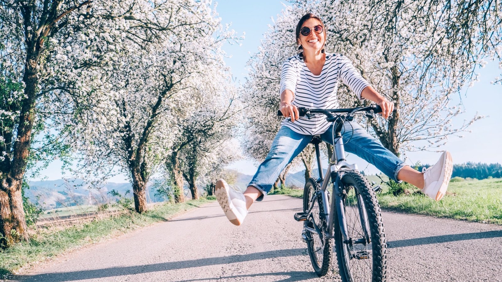 Happy smiling woman on a bike bicycle outdoors fitness Soloviova Liudmyla Shutterstock