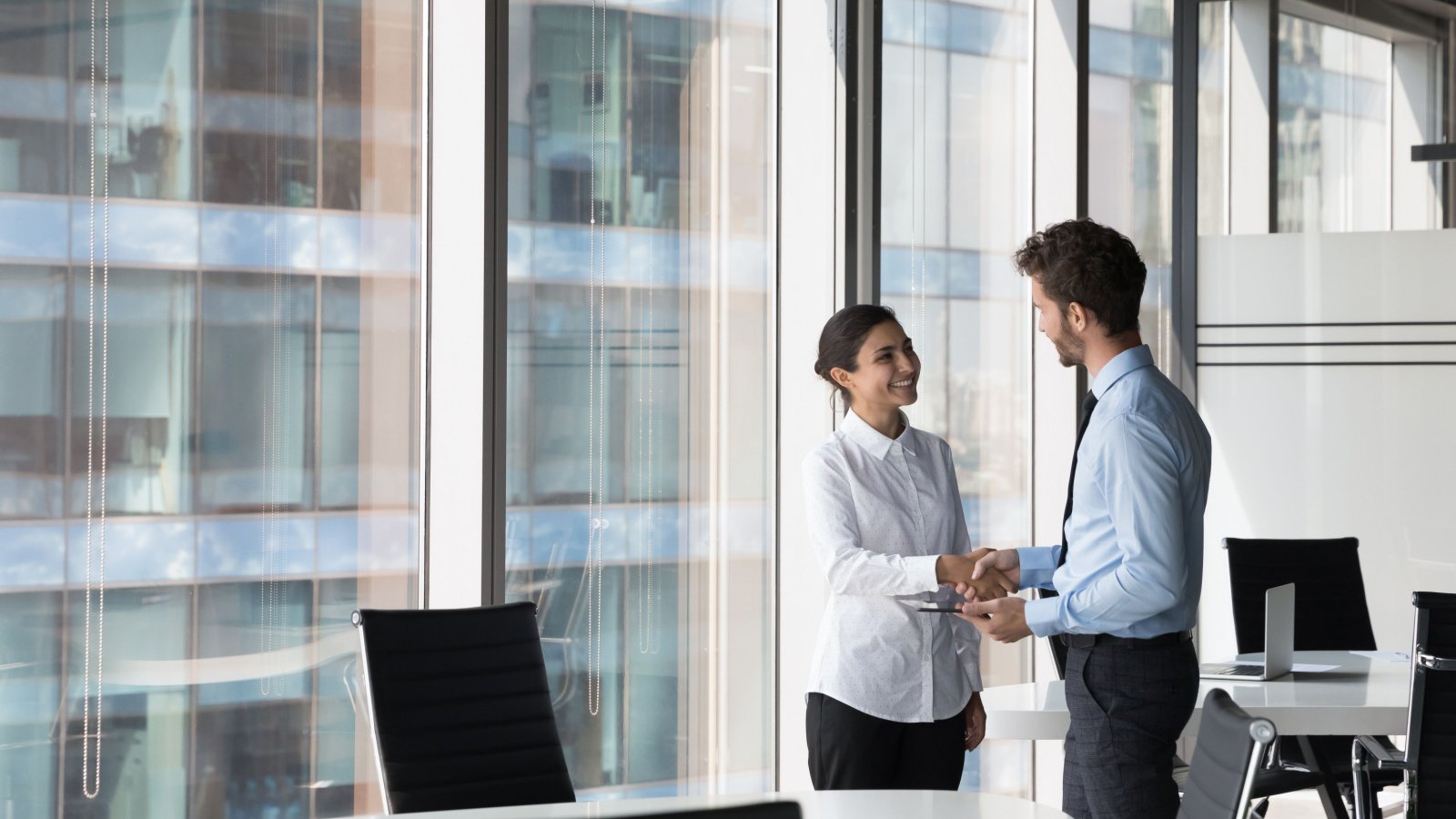 Investors finance hand shake business meeting deal woman male office fizkes Shutterstock