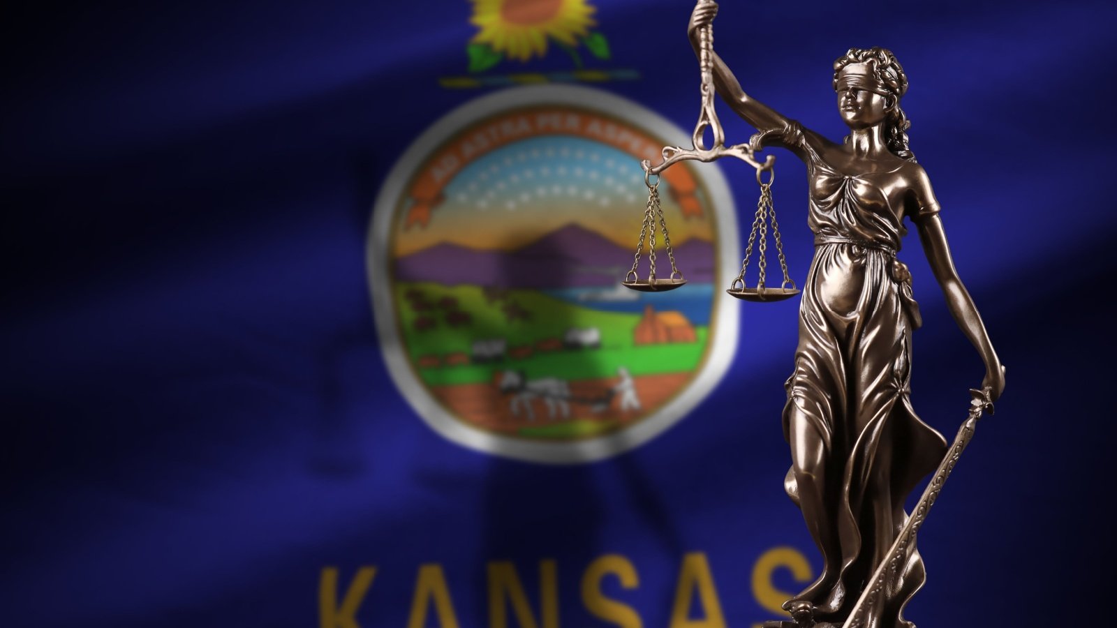 Kansas state flag with statue of lady justice and judicial scales law legal Mehaniq Shutterstock