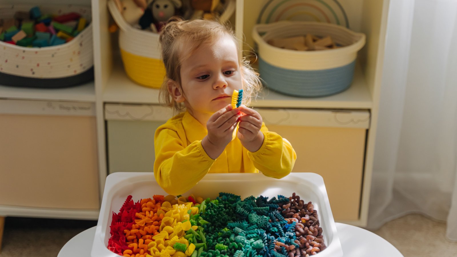 Kid child girl sensory bin play Montessori Igisheva Maria Shutterstock