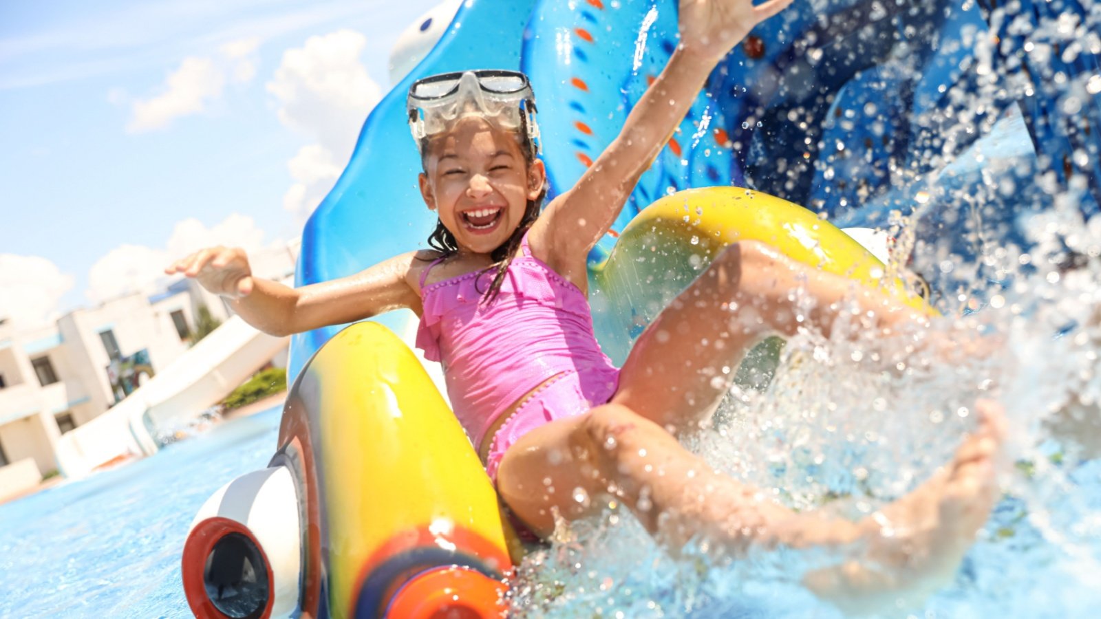 Little girl on slide at water park child kid swimming summer fun splash pool New Africa Shutterstock