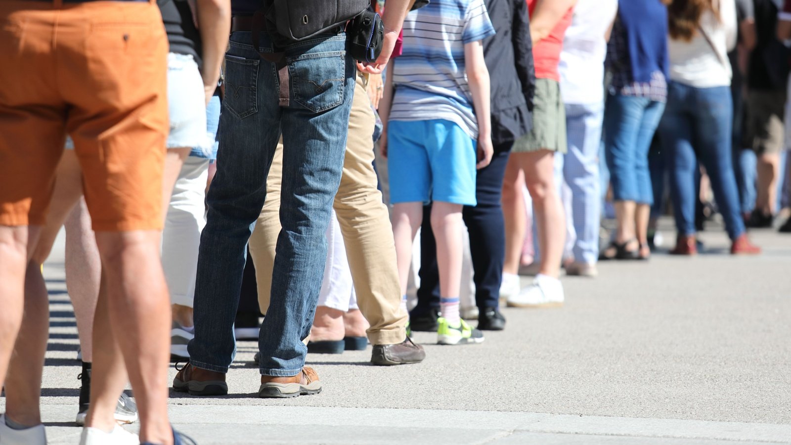 Long queue of people waiting in line standing TK Kurikawa Shutterstock