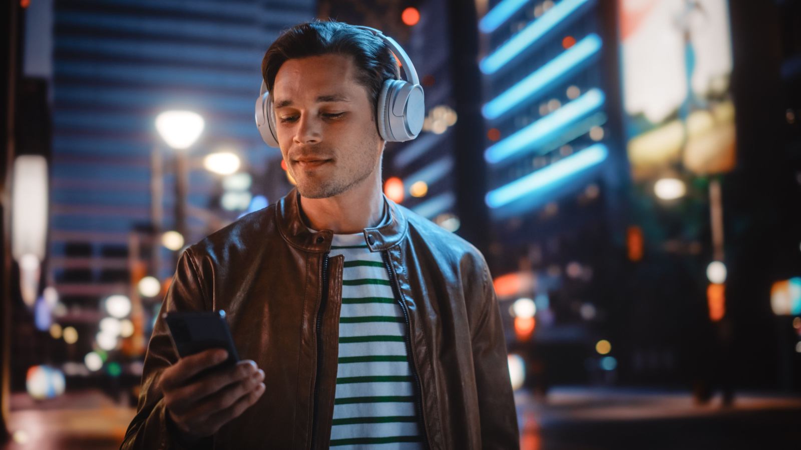 Male Listening Music headphones phone city walk night Gorodenkoff Shutterstock