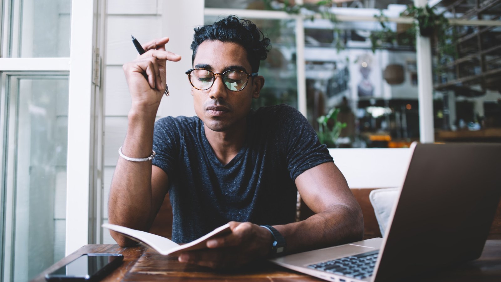 Male journaling thinking work computer introspection self care reflection GaudiLab Shutterstock