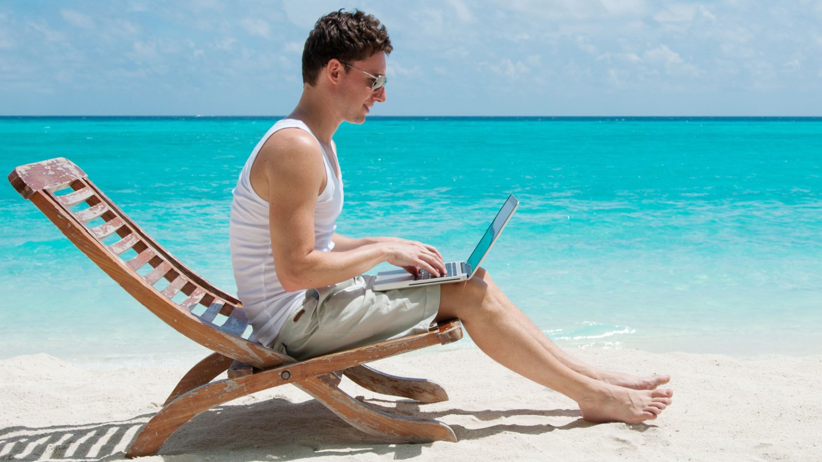 Male relaxing at the beach with laptop remote maxim safronov shutterstock