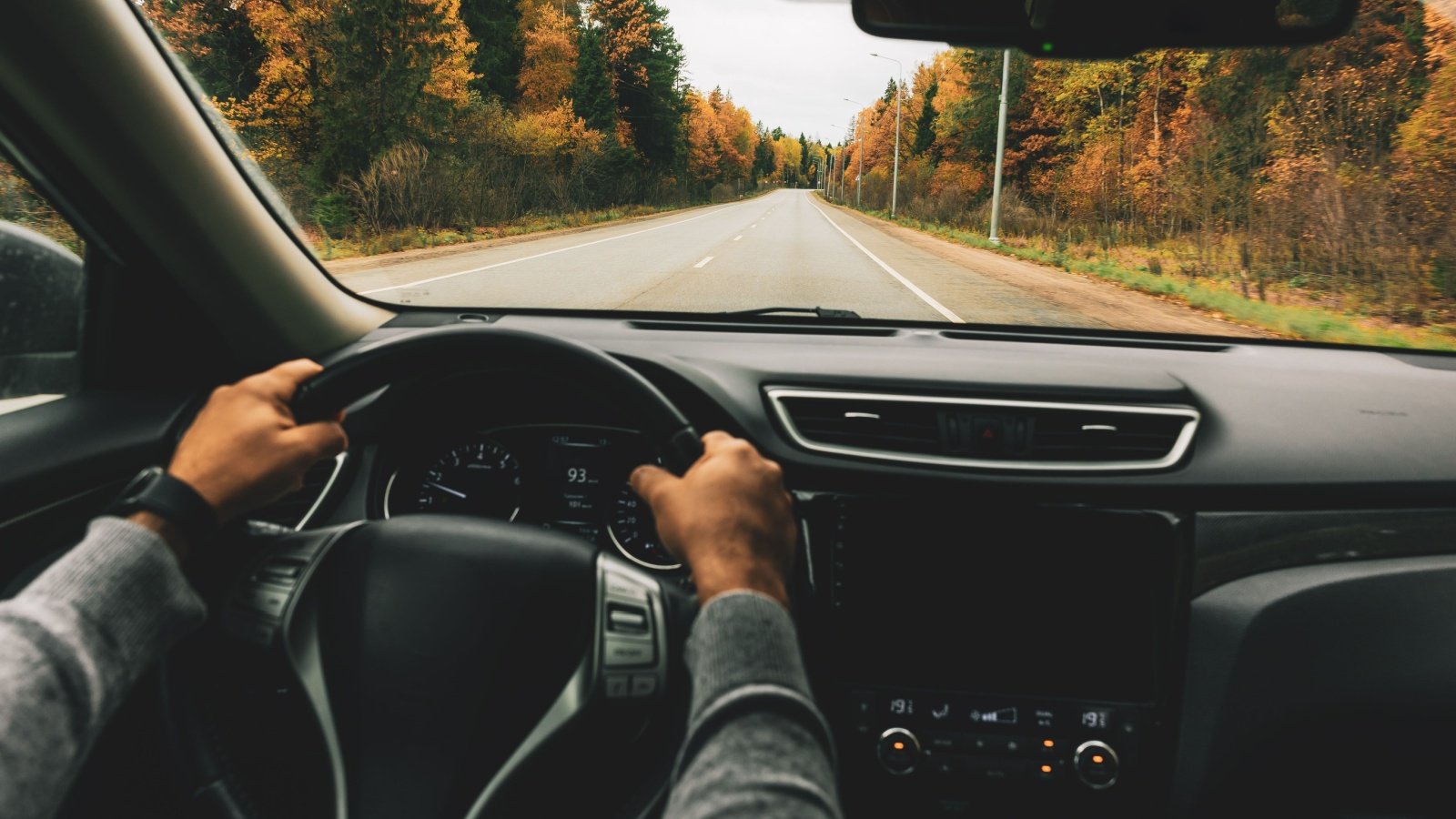 Man driving car on the country road drive trip wheel nblx Shutterstock