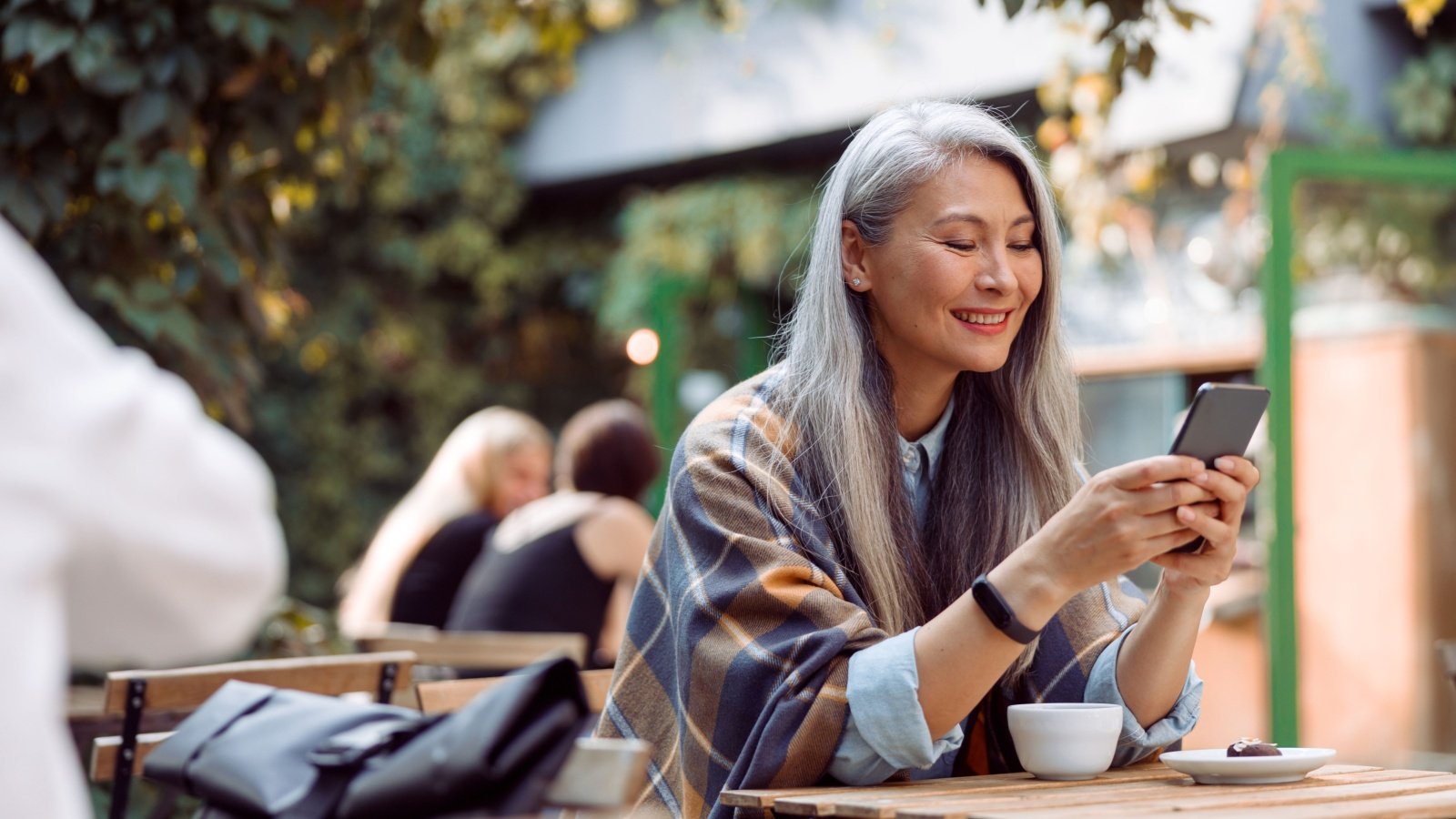 Mature Woman Drinking Coffee on Phone Yaroslav Astakhov Shutterstock