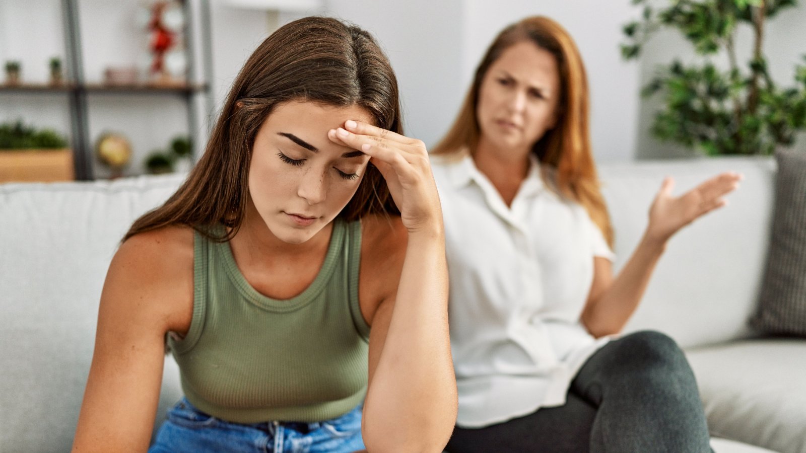 Mother and daughter unhappy arguing sitting on sofa at home fight kraken images shutterstock