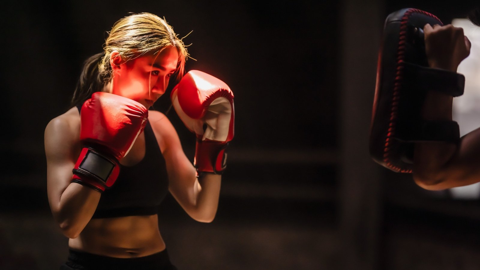 Muay Thai boxer woman with red boxing gloves training in gym workout exercise Jacktamrong Shutterstock