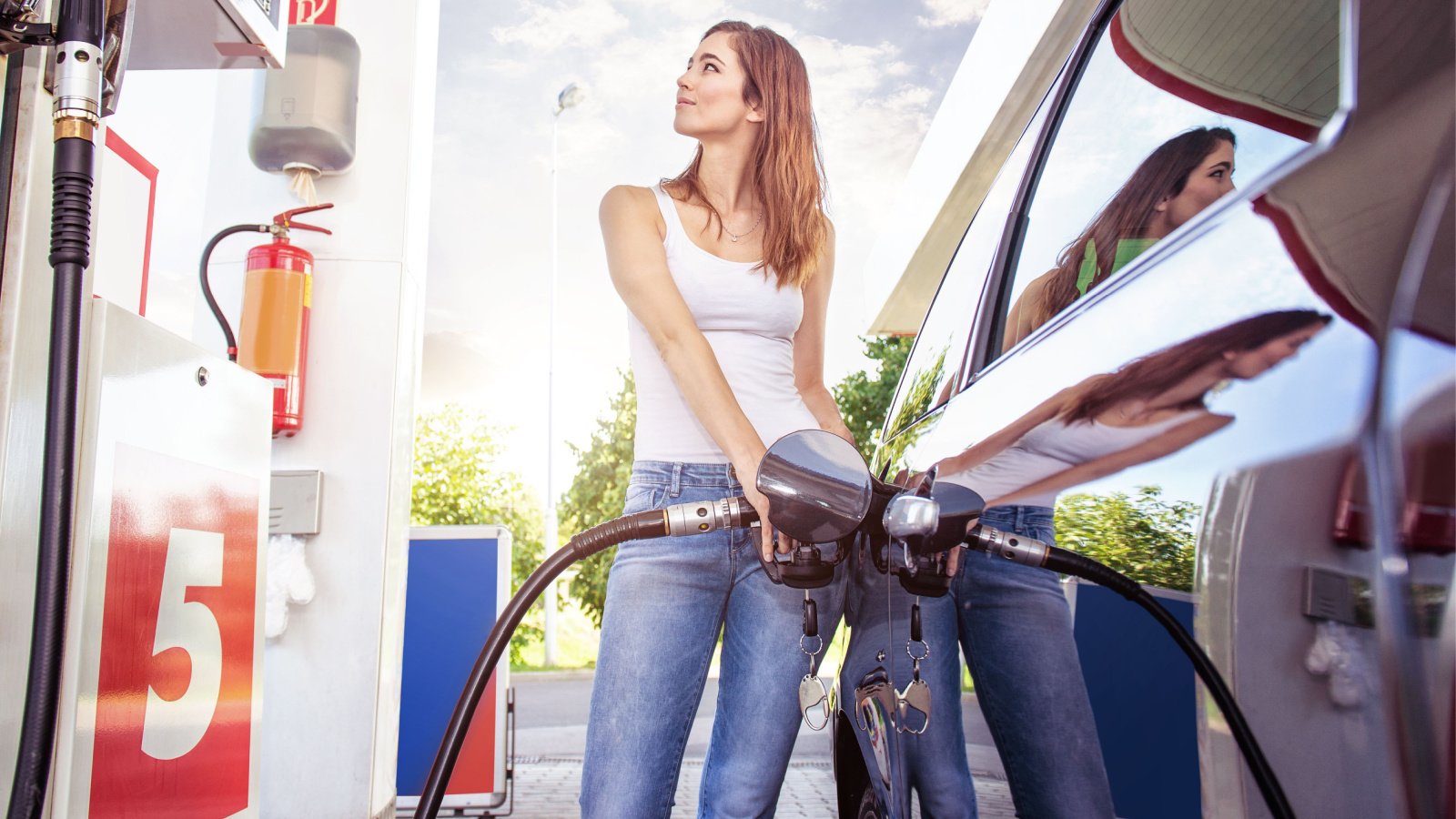 Pretty young woman refuel the car pumping gas station gergely zsolnai shutterstock