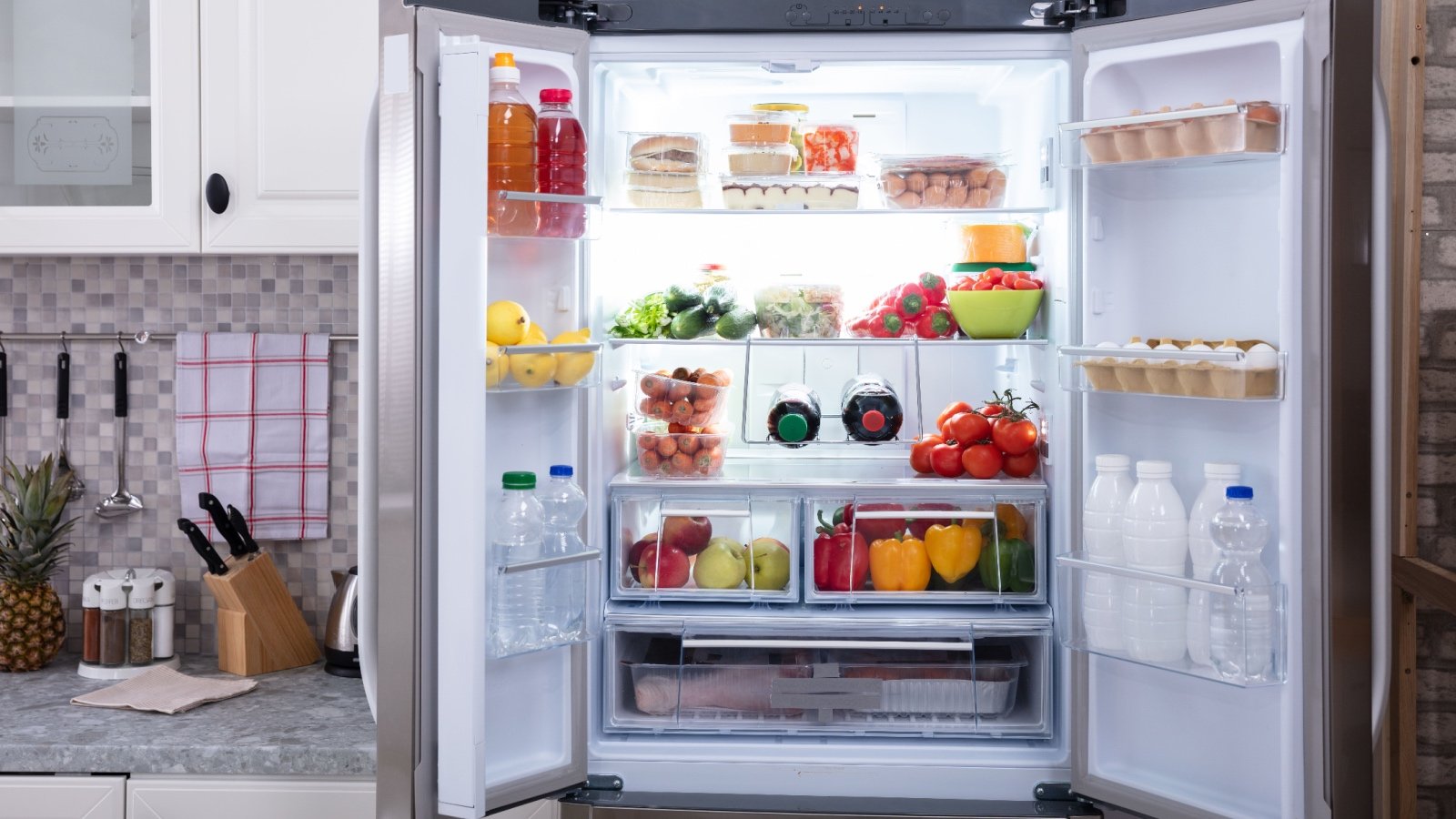 Refrigerator with fruit vegetable eggs juice and water Andrey Popov Shutterstock