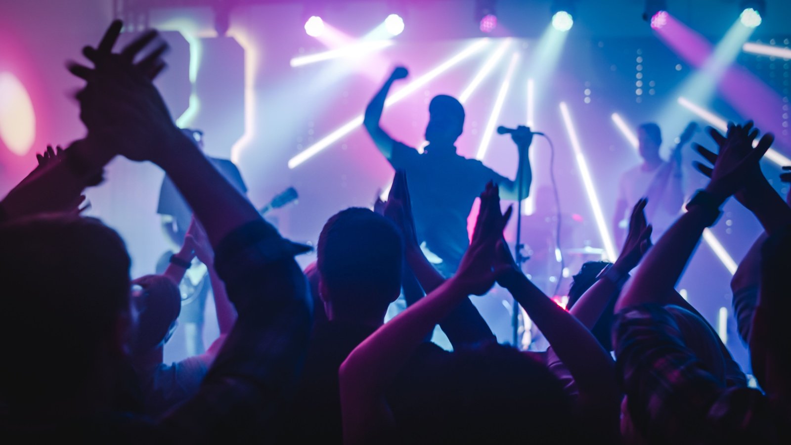 Rock Band with Guitarists and Drummer Performing at a Concert in a Night Club Gorodenkoff Shutterstock