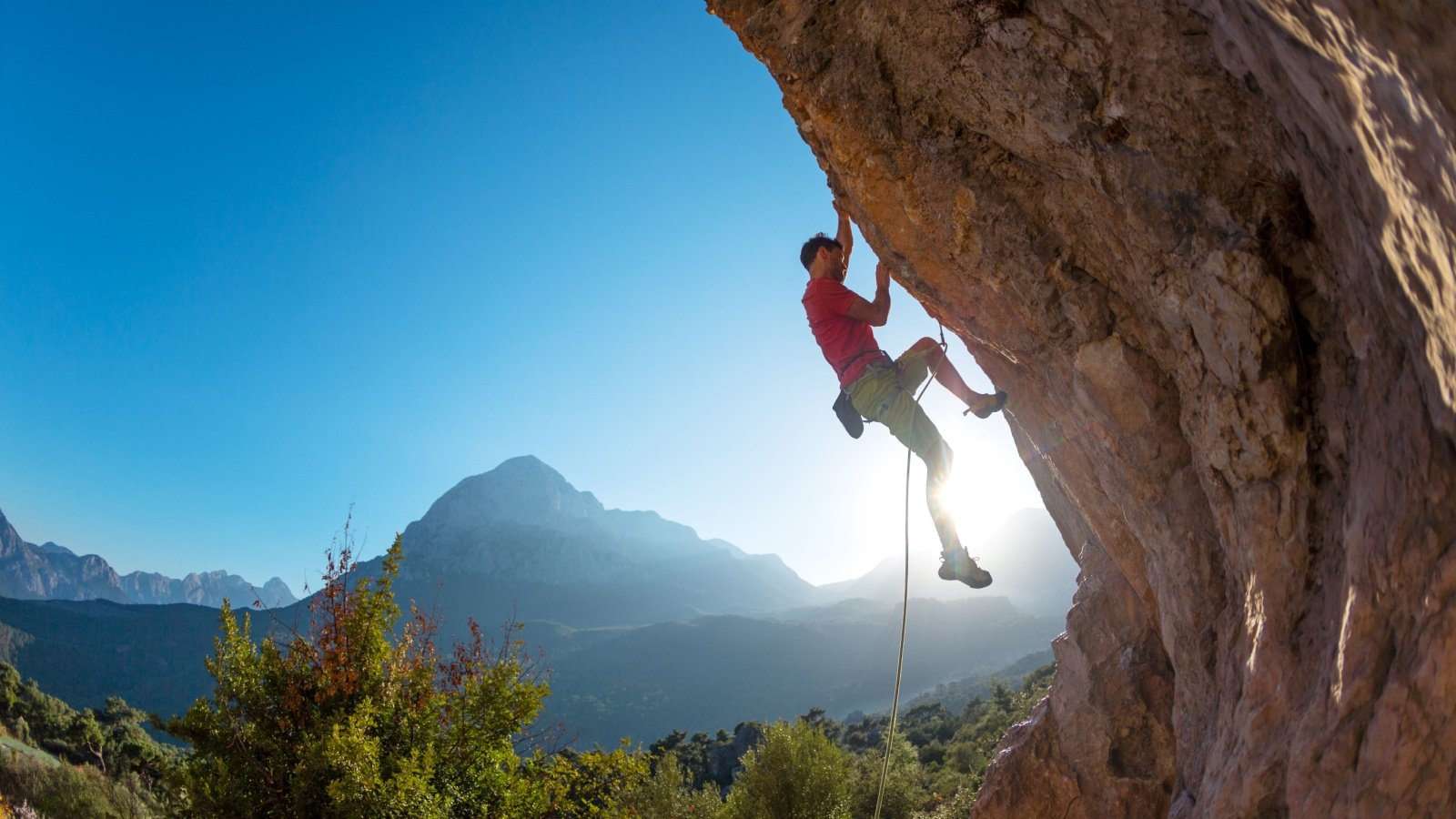 Rock climber climbing rope canyon mountain sports exercise outdoor recreation Photo Volcano Shutterstock