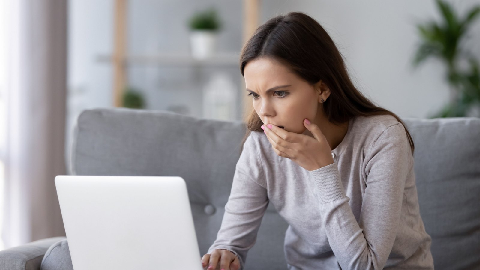 Shocked stressed young woman computer laptop social fizkes Shutterstock