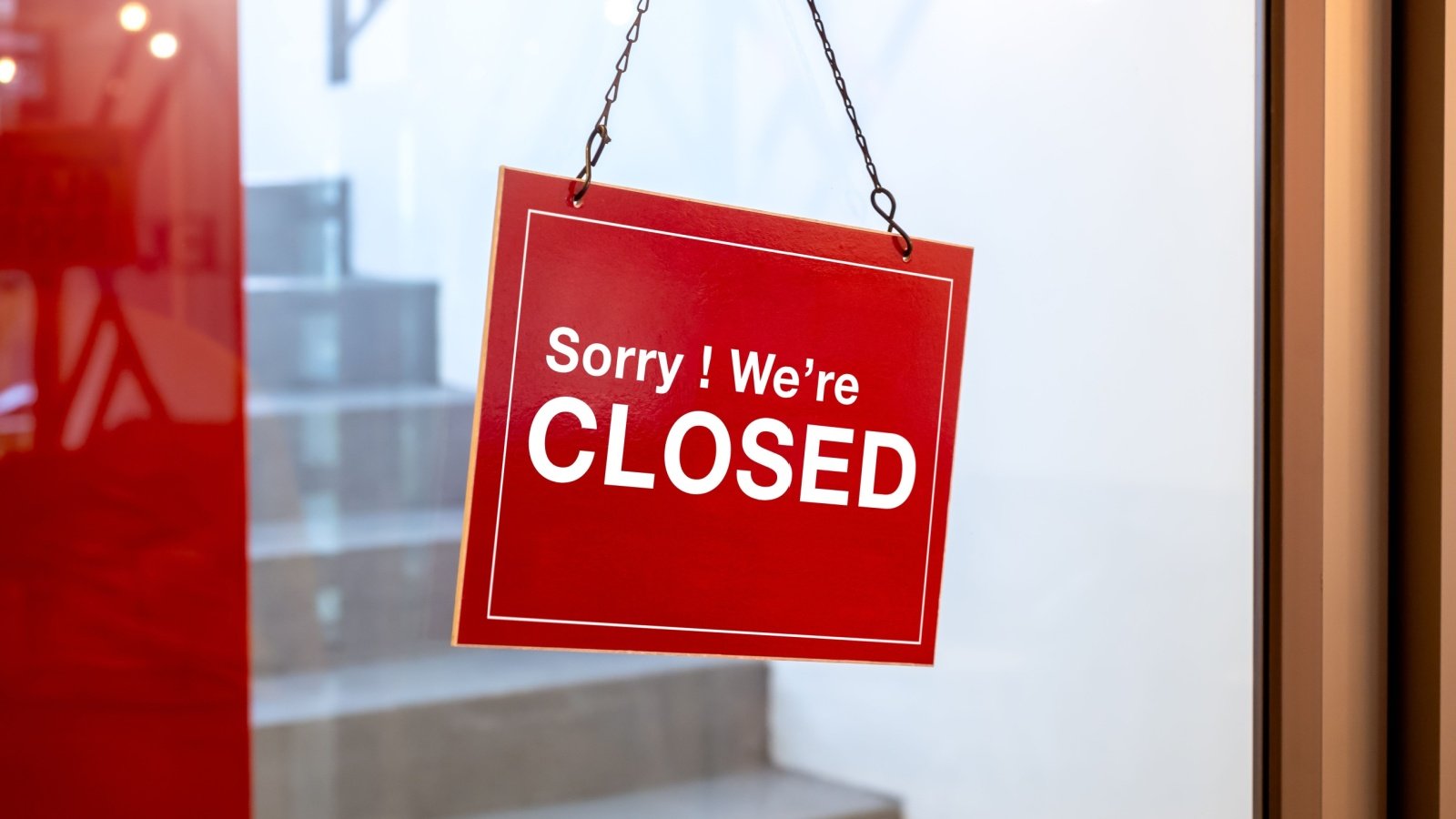 Sorry were closed sign on store front door shop hours business closure tete escape Shutterstock