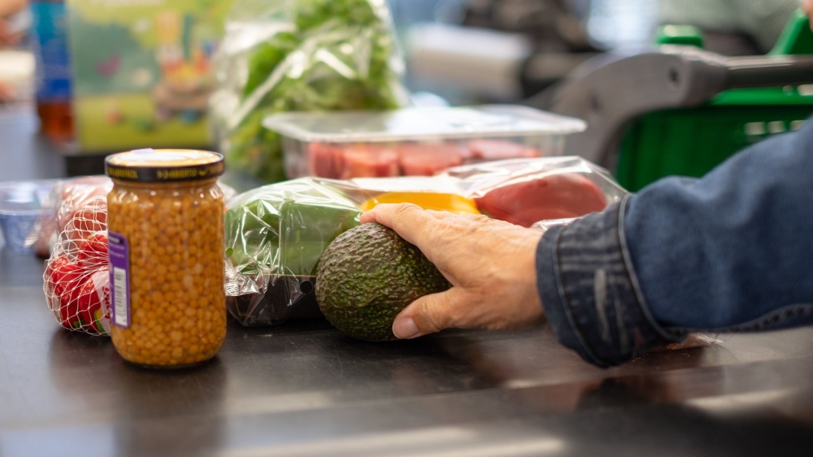 Supermarket grocery store checkout conveyor belt produce avocado produce shop Lucigerma Shutterstock