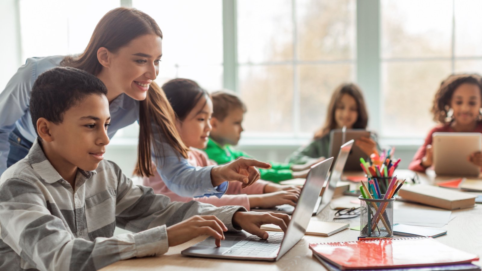 Teacher classroom education students laptops Prostock studio Shutterstock