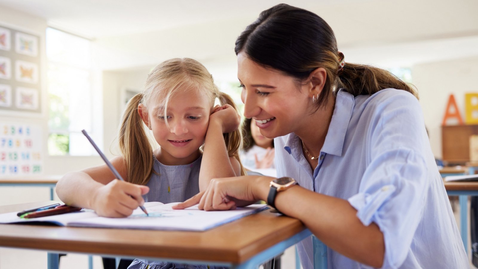 Teacher helps student classroom draw write PeopleImages.com Yuri A Shutterstock