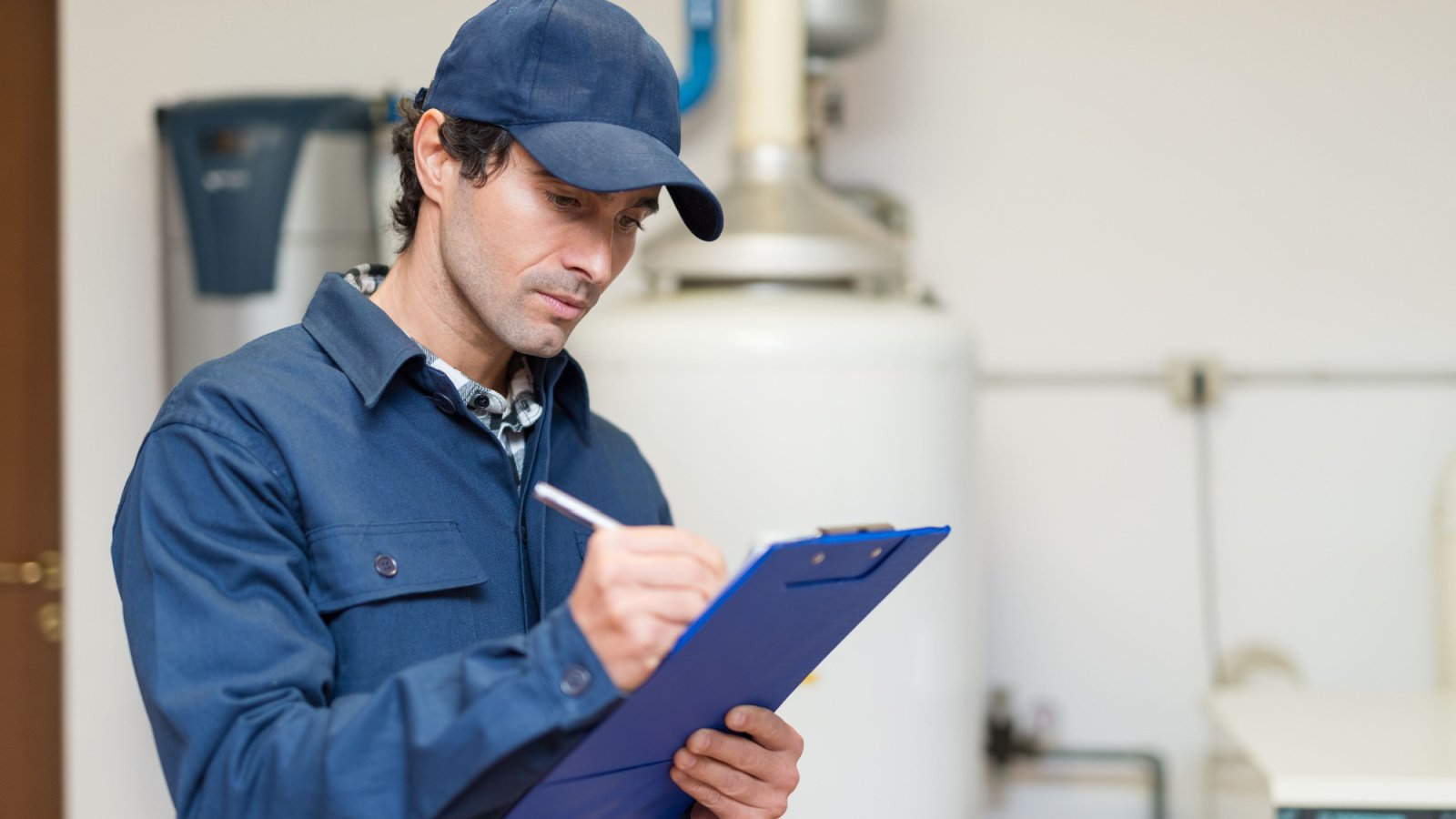 Technician servicing an hot water heater maintenance repair Minerva Studio Shutterstock