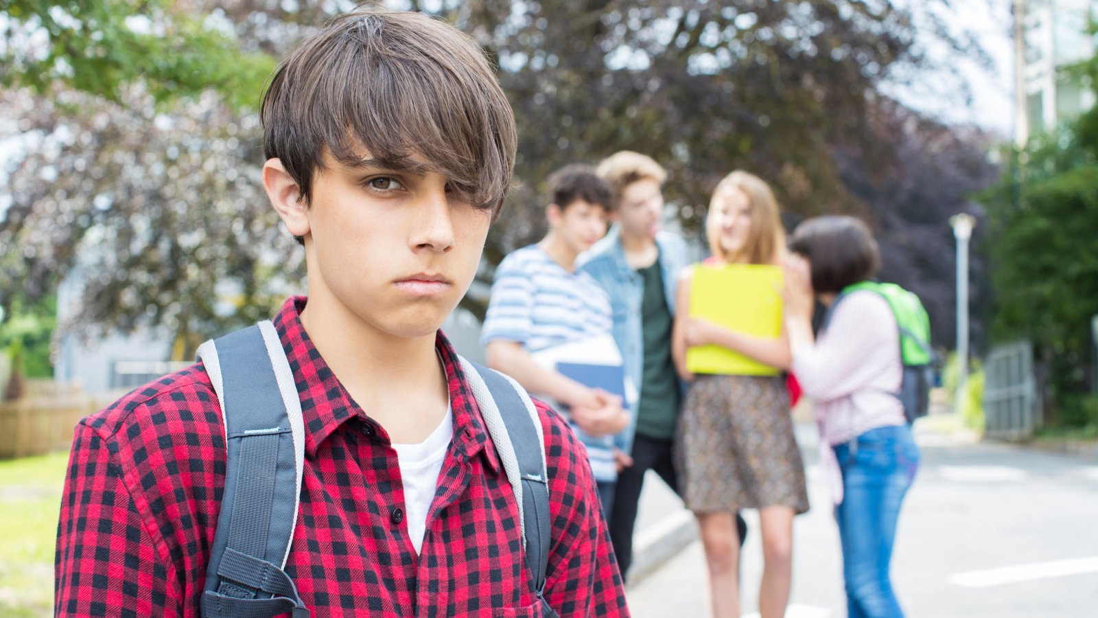 Unhappy teenager Boy Being Gossiped About By School daisy daisy shutterstock