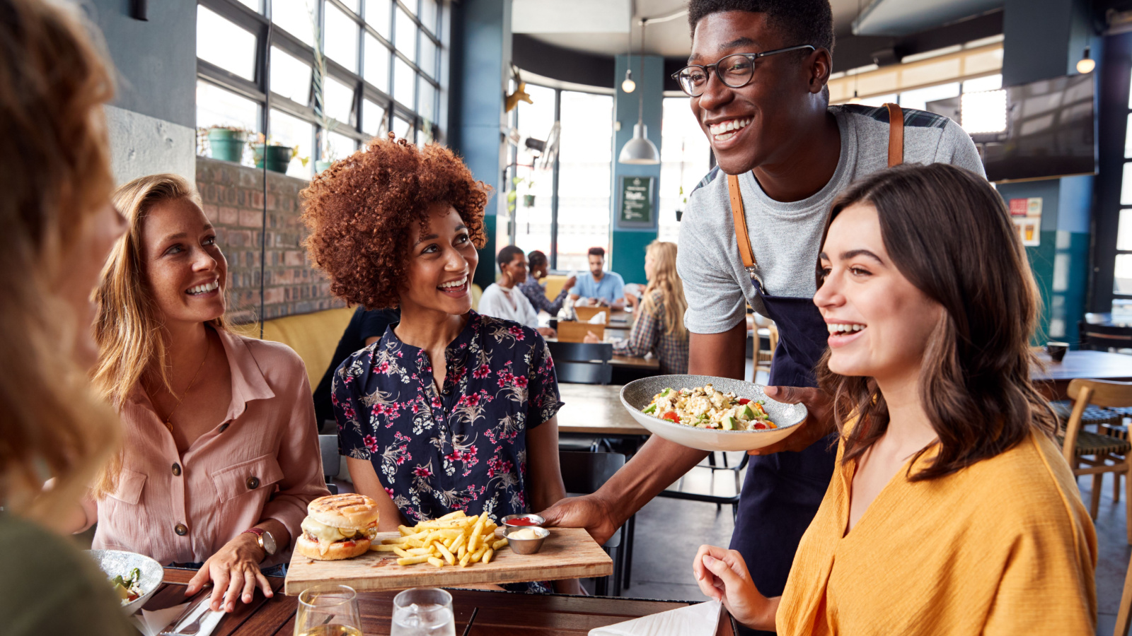 Waiter Server POC Restaurant food friends woman Monkey Business Images Shutterstock