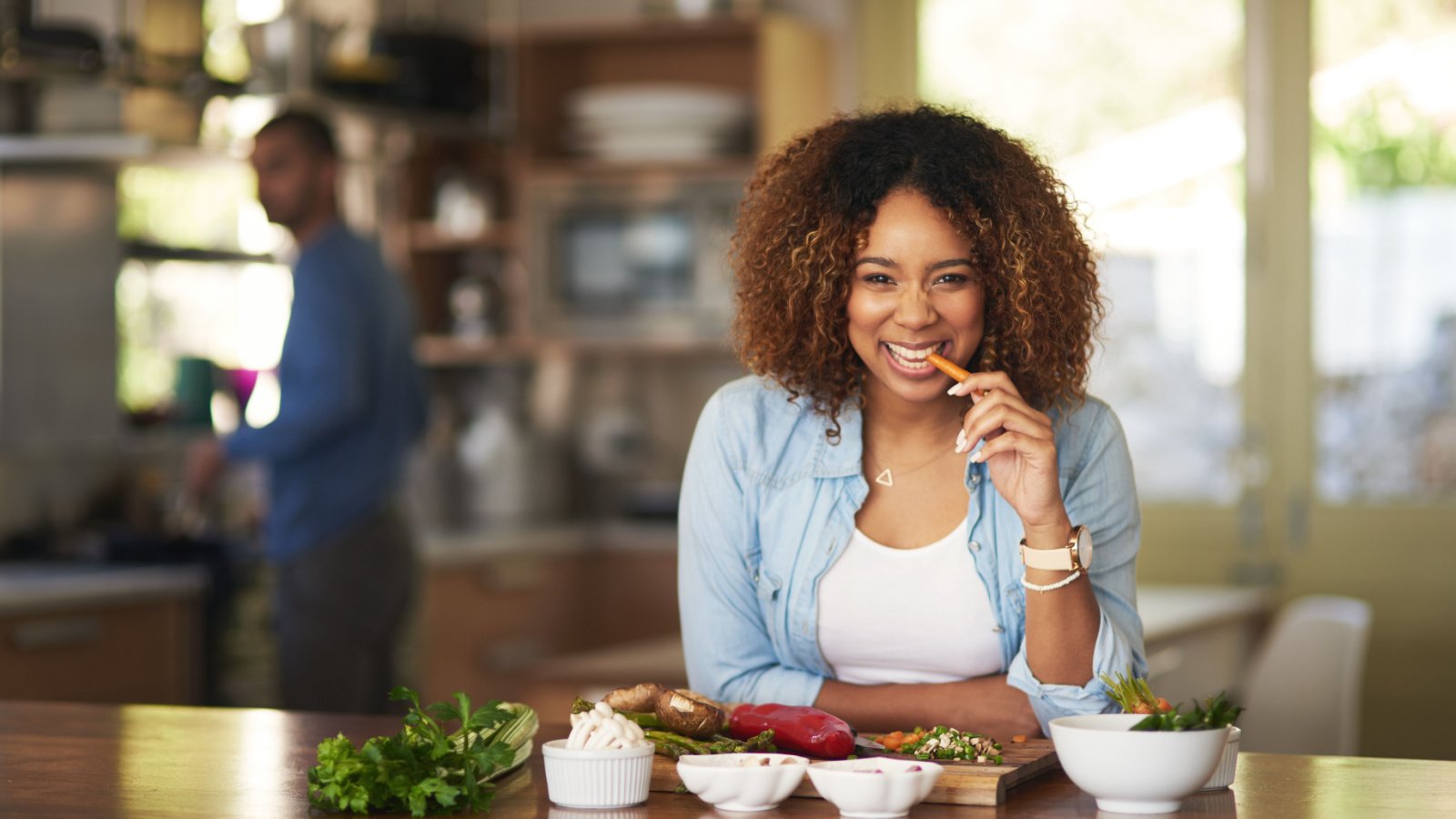 Woman Eat Carrot Vegetables Kitchen PeopleImages.com Yuri A Shutterstock